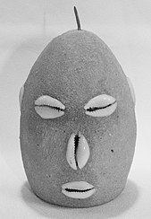 A concrete head with cowry shells for eyes, nose and mouth